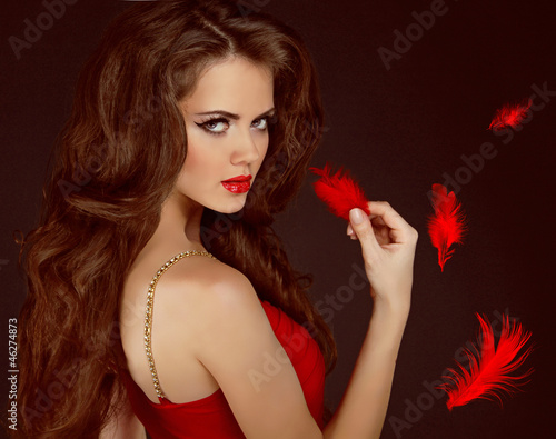 Woman with beauty long curly brown hair and red lips. Fashion wo