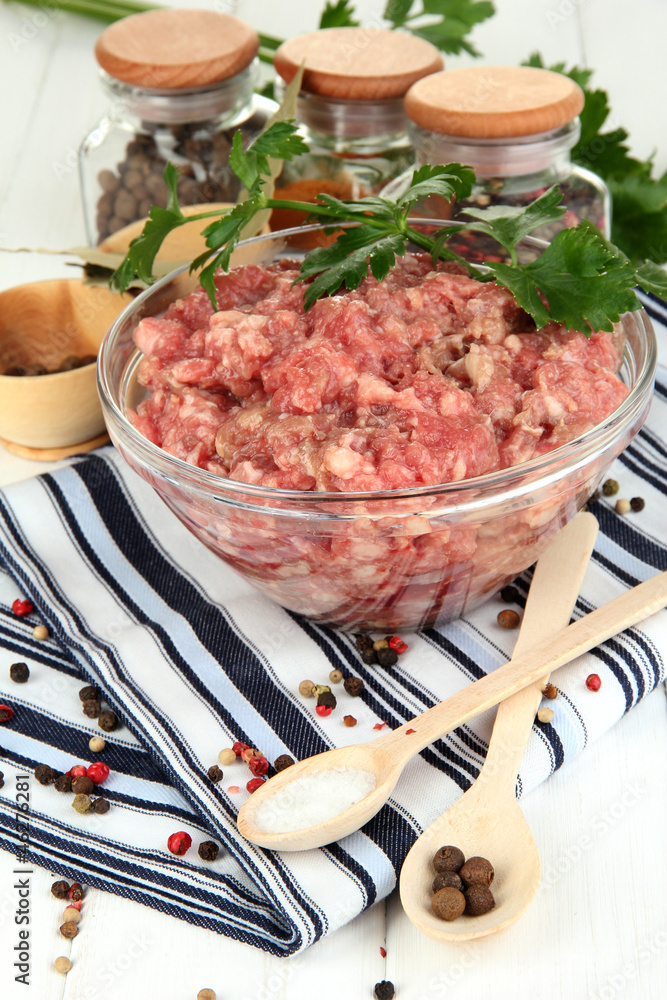 Bowl of raw ground meat with spices on wooden table Bowl of raw ground meat with spices on wooden table