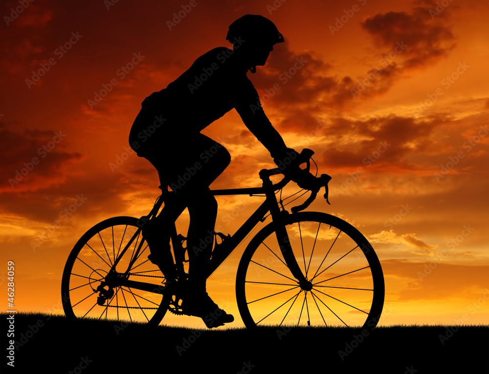 silhouette of the cyclist riding a road bike at sunset silhouette of the cyclist riding a road bike at sunset