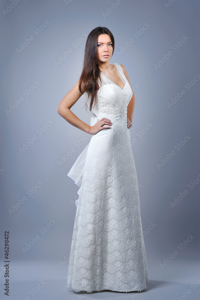 Slim beautiful woman with long hair wearing luxurious wedding dr