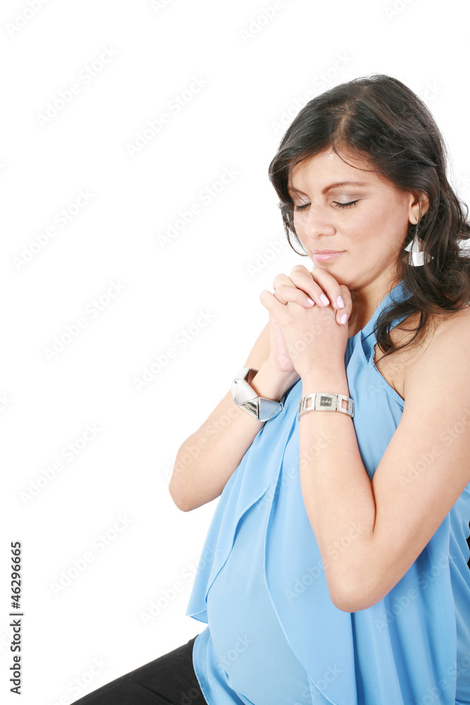 Hispanic pregnant woman praying with hands together Hispanic pregnant woman praying with hands together