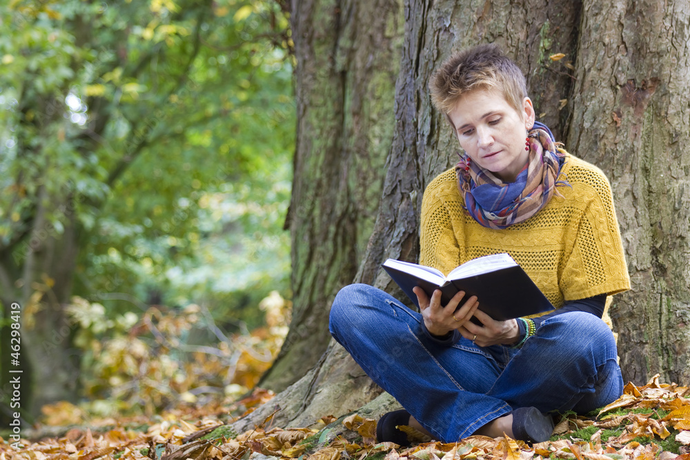 Fototapeta premium Woman reading book in the park
