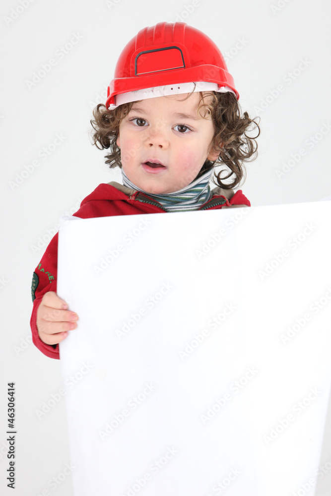 Child dressed as a builder with a blank board Child dressed as a builder with a blank board