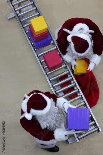 santa clauses preparing gifts in factory