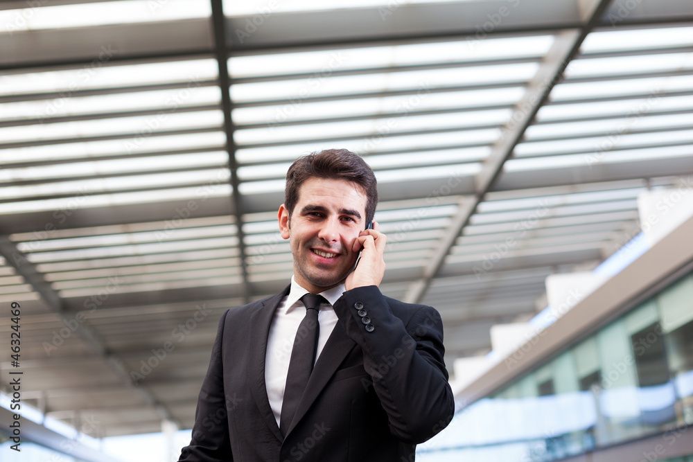 Young business man talking on cell phone at modern office Young business man talking on cell phone at modern office