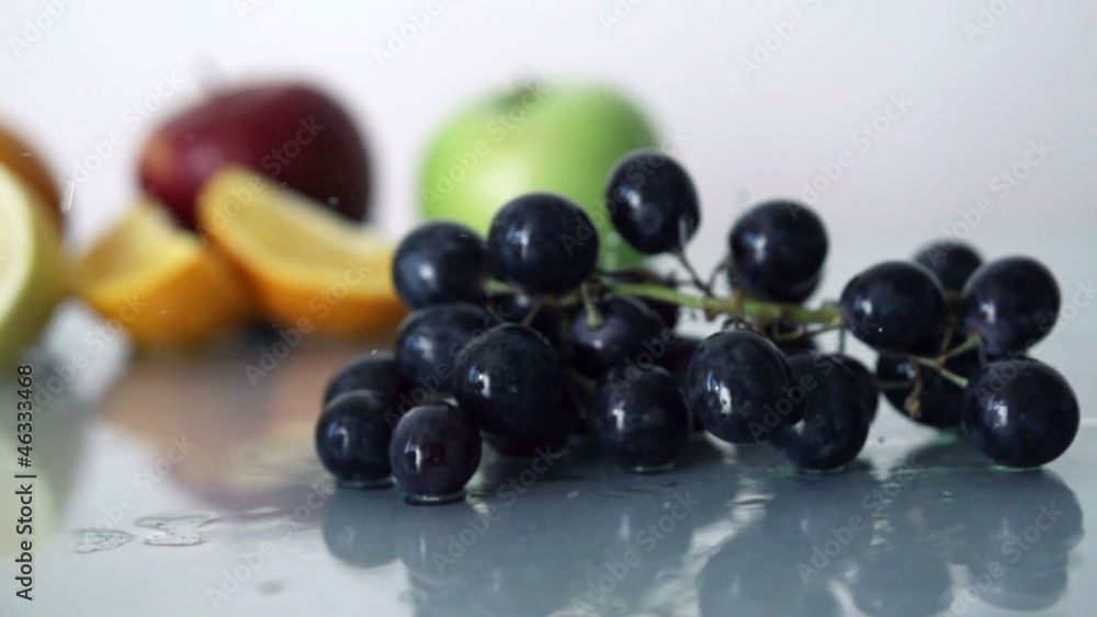 Bunch of grapes falling on glass surface, slow motion Bunch of grapes falling on glass surface, slow motion