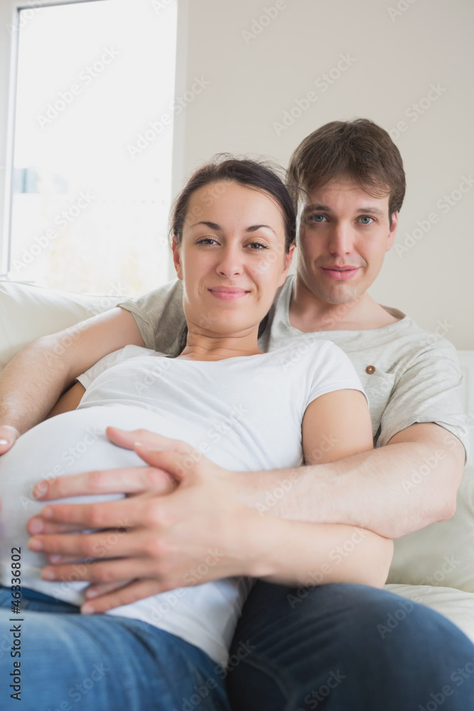 Pregnant woman lying on couch with partner Pregnant woman lying on couch with partner