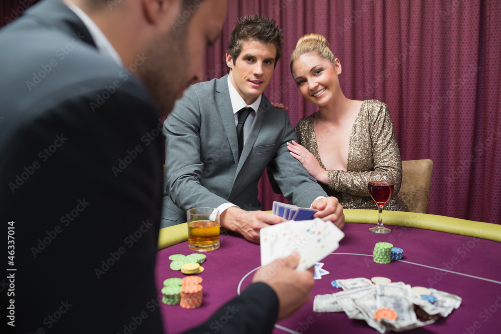 Couple playing poker and smiling Couple playing poker and smiling