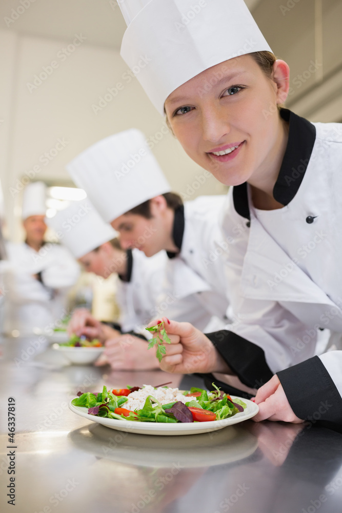 Smiling chef preparing salad in culinary class Smiling chef preparing salad in culinary class