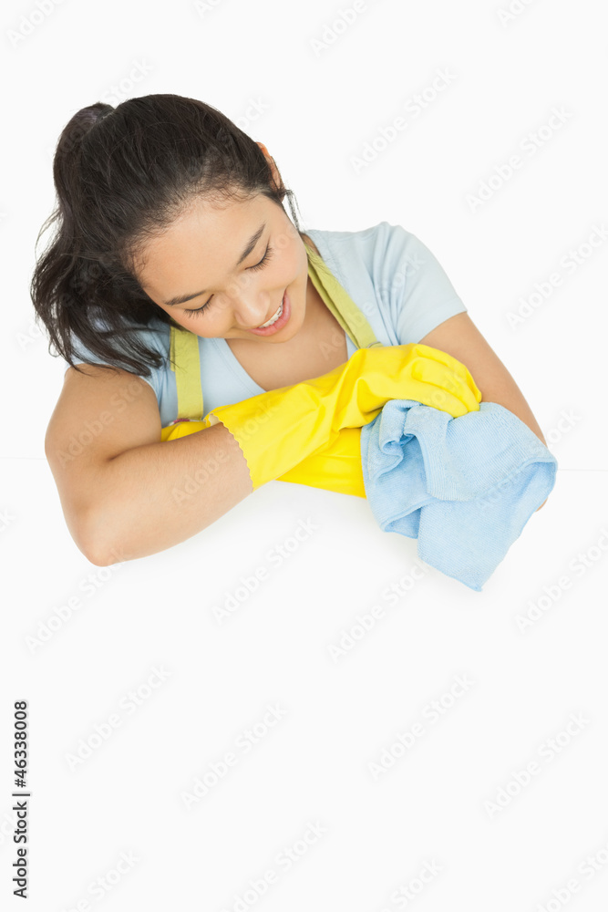 Happy woman with blue rag leaning on white surface Happy woman with blue rag leaning on white surface