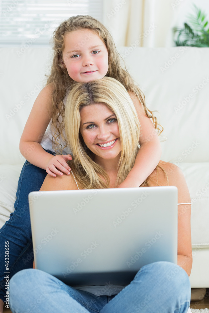 Daughter hugging her mother using laptop Daughter hugging her mother using laptop