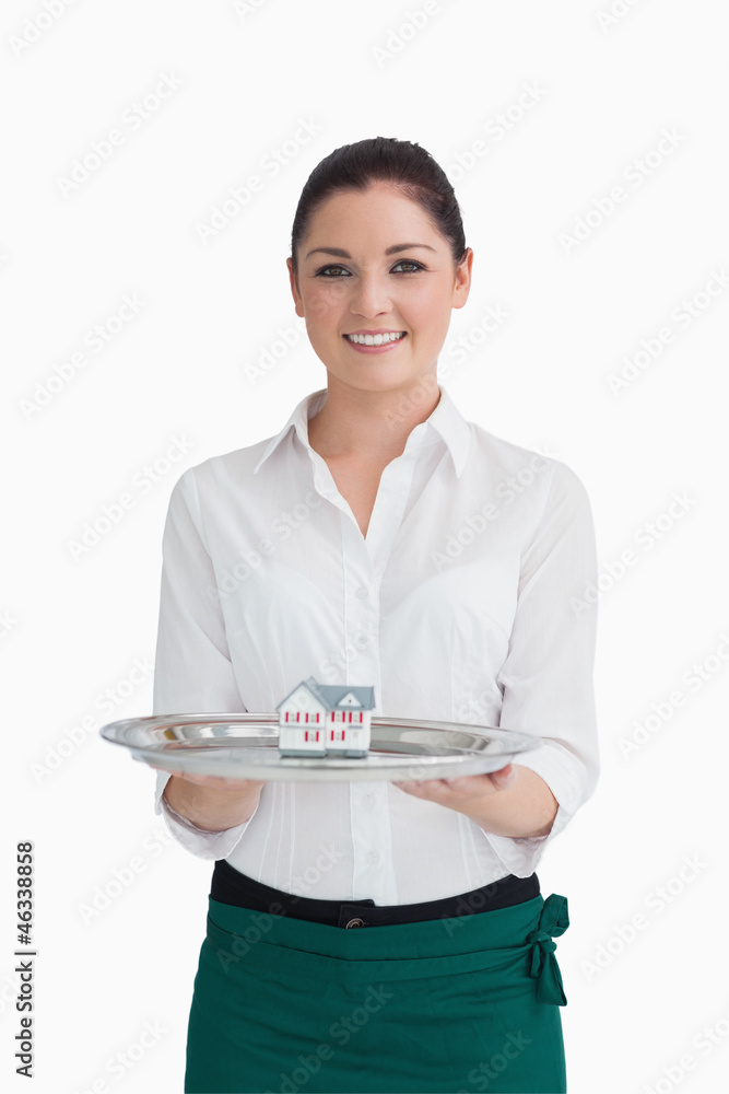 Waitress presenting miniature house on tray Waitress presenting miniature house on tray
