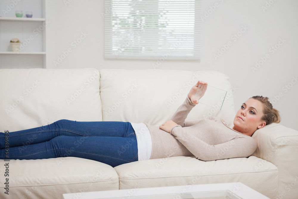 Woman lying on the sofa while viewing a pane Woman lying on the sofa while viewing a pane