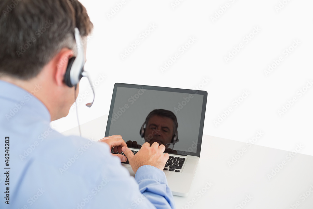 Businessman with headset working on laptop Businessman with headset working on laptop