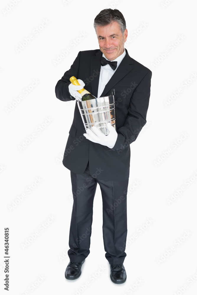 Waiter offering bottle of champagne in cooler Waiter offering bottle of champagne in cooler