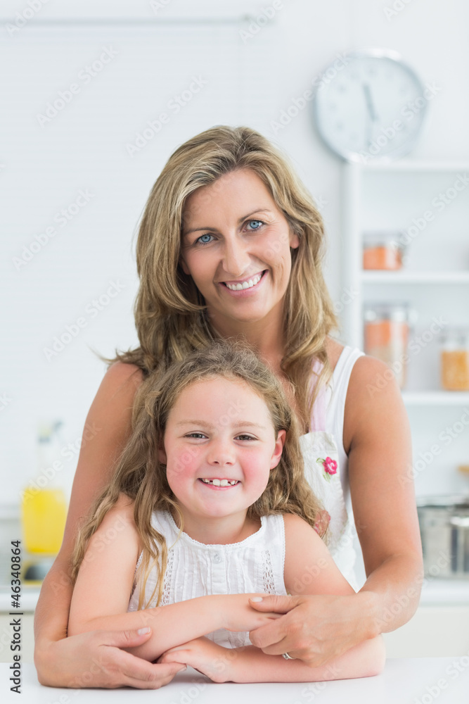 Mother hugging daughter in the kitchen