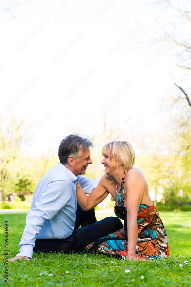 Fototapeta premium Älteres Paar im Frühling in auf einer Wiese in der Stadt