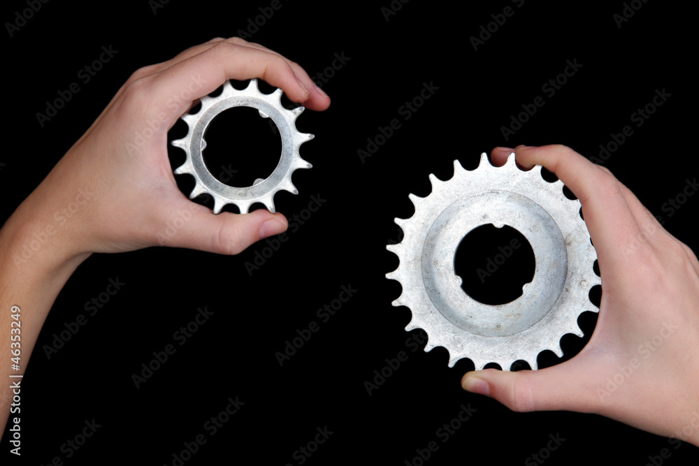 Man holding a pair of old metallic cogwheels in his hands Man holding a pair of old metallic cogwheels in his hands