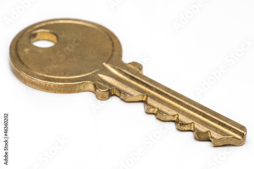 Brass key on isolated white background.