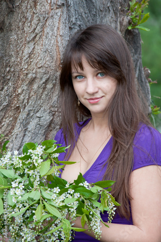 woman on nature in a park with the sprigs of flowering bird cher