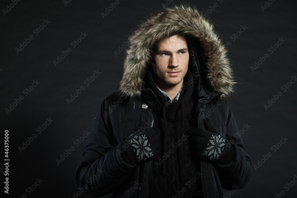 Handsome man dark winter fashion. Studio shot. Wearing hoody. Handsome man dark winter fashion. Studio shot. Wearing hoody.