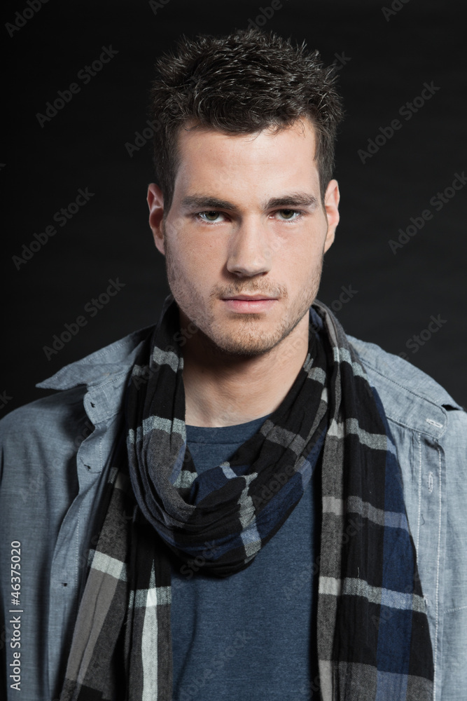 Fototapeta premium Handsome man dark winter fashion. Studio shot. Wearing scarf.