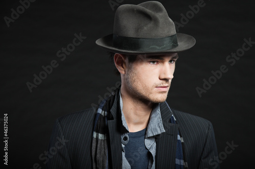 Handsome man dark winter fashion. Studio shot. Wearing hat. © ysbrandcosijn