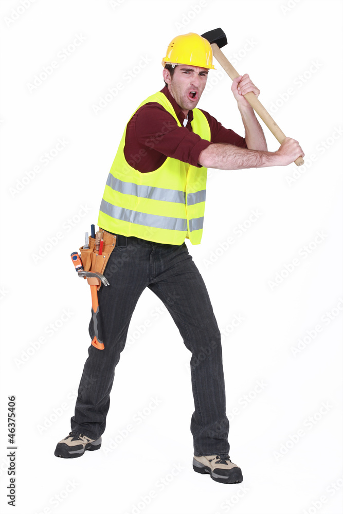 Construction worker smashing with a sledgehammer Construction worker smashing with a sledgehammer