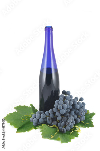 Blue bottle of wine and ripe grapes