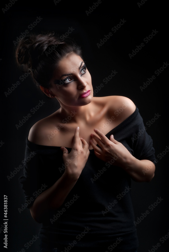 Young attractive fashion model posing on dark background