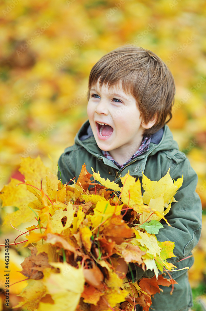Little boy screaming while holding leaves in the park Little boy screaming while holding leaves in the park