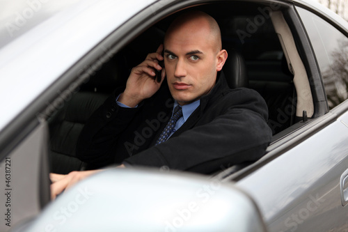 Bald businessman making call from car