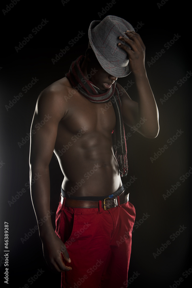 Naklejka premium Black man looking at the floor with his hat covering his eyes