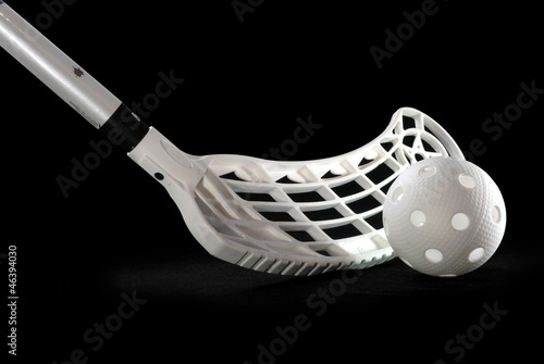 A silver floorball stick and white ball