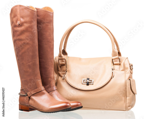 Women knee-high boots and leather bag over white