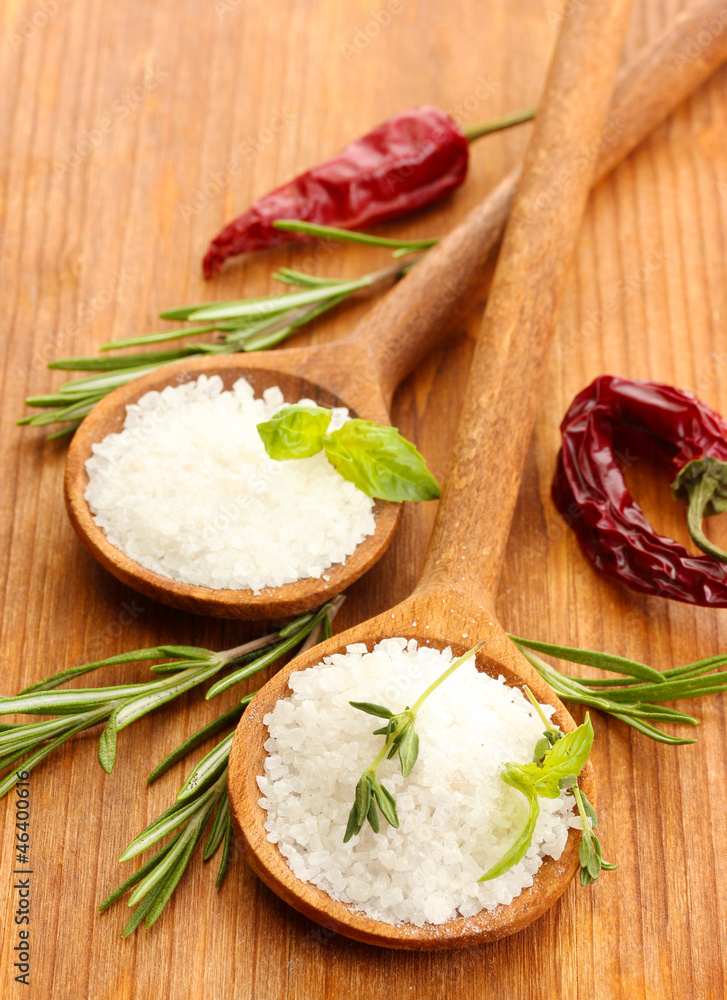 salt in spoons with herbs and vegetables isolated on white salt in spoons with herbs and vegetables isolated on white