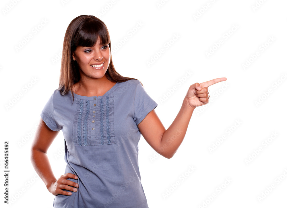 Latin young woman looking and pointing her left Latin young woman looking and pointing her left