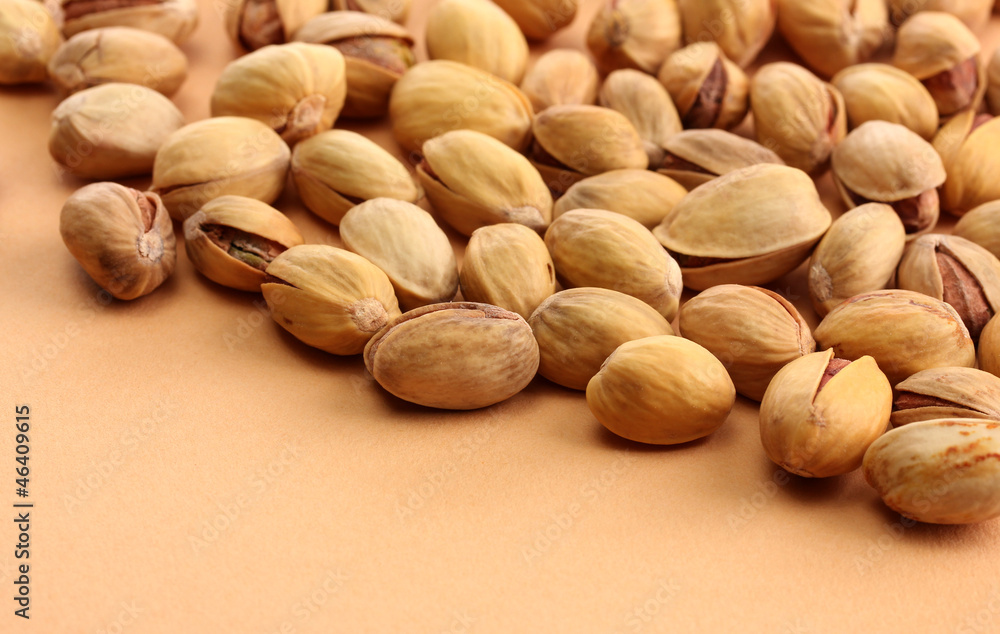tasty pistachio nuts, on beige background tasty pistachio nuts, on beige background