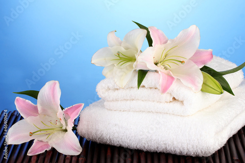 stack of towels with pink lily on blue background