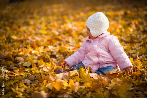 Infant baby girl in golden autumn park