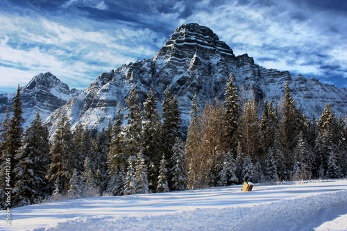 Rocky mountain peaks under clouds in a blue sky