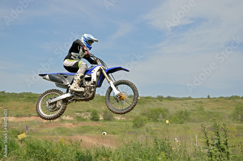 MX rider sitting on the motorbike in the air