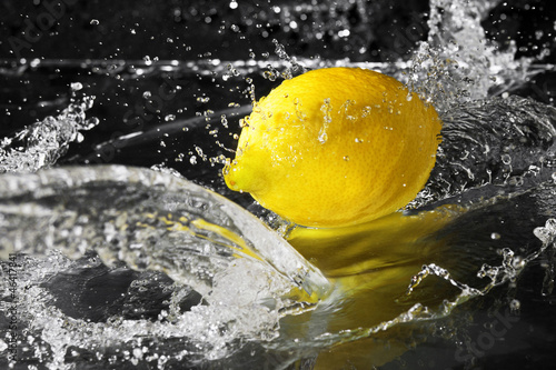 fresh water drops on lemon on black background