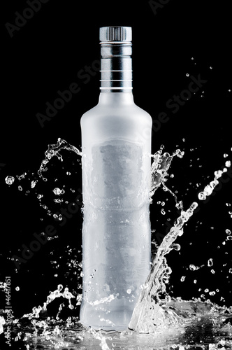 Photo iced bottle of vodka splash on a black background