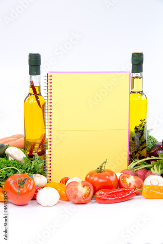 Fototapeta Naklejka Na Ścianę i Meble -  Yellow paper for recipes with olive oil bottles and vegetable