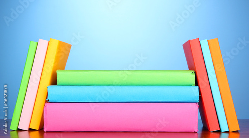 Stack of multicolor books   on blue background