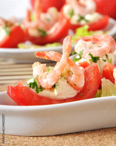 Halves of tomatoes filled with shrimp cocktail 