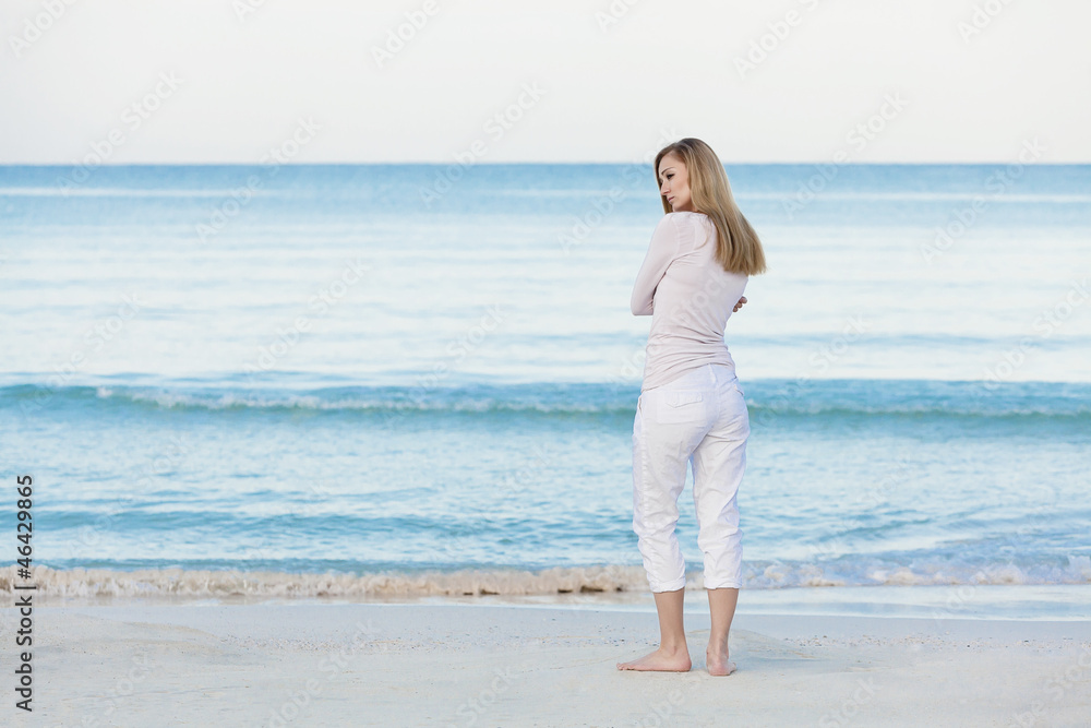 Hübsche blonde junge frau entspannt sich alleine am Strand am m