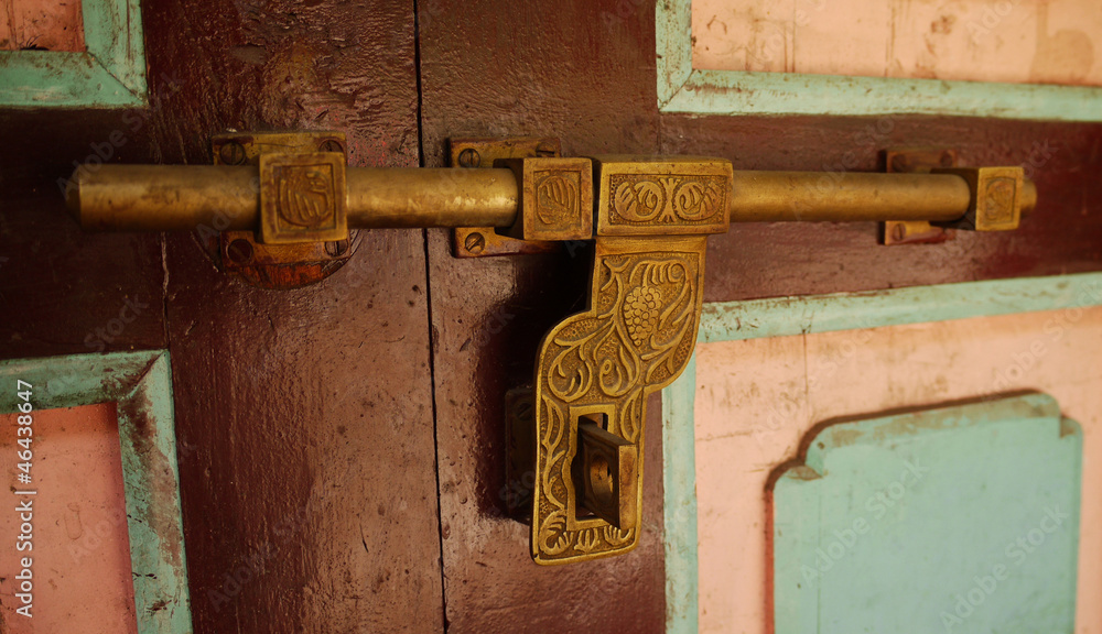 Old brass latch on the door of a house in Nepal. Old brass latch on the door of a house in Nepal.
