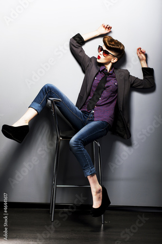 Pin-up girl in sunglasses sitting. American retro style